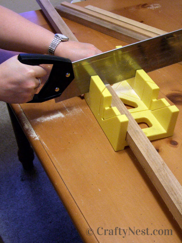 cutting-diy-bulletin-board-with-shutters-crafty-nest Cutting the bulletin board frame pieces with a miter box and pull saw, photo