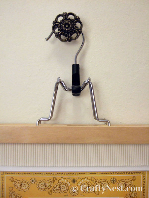 closeup-pull-with-hanger-diy-pants-hanger-picture-frames-crafty-nest Close up of the hanger hanging on the knob, photo