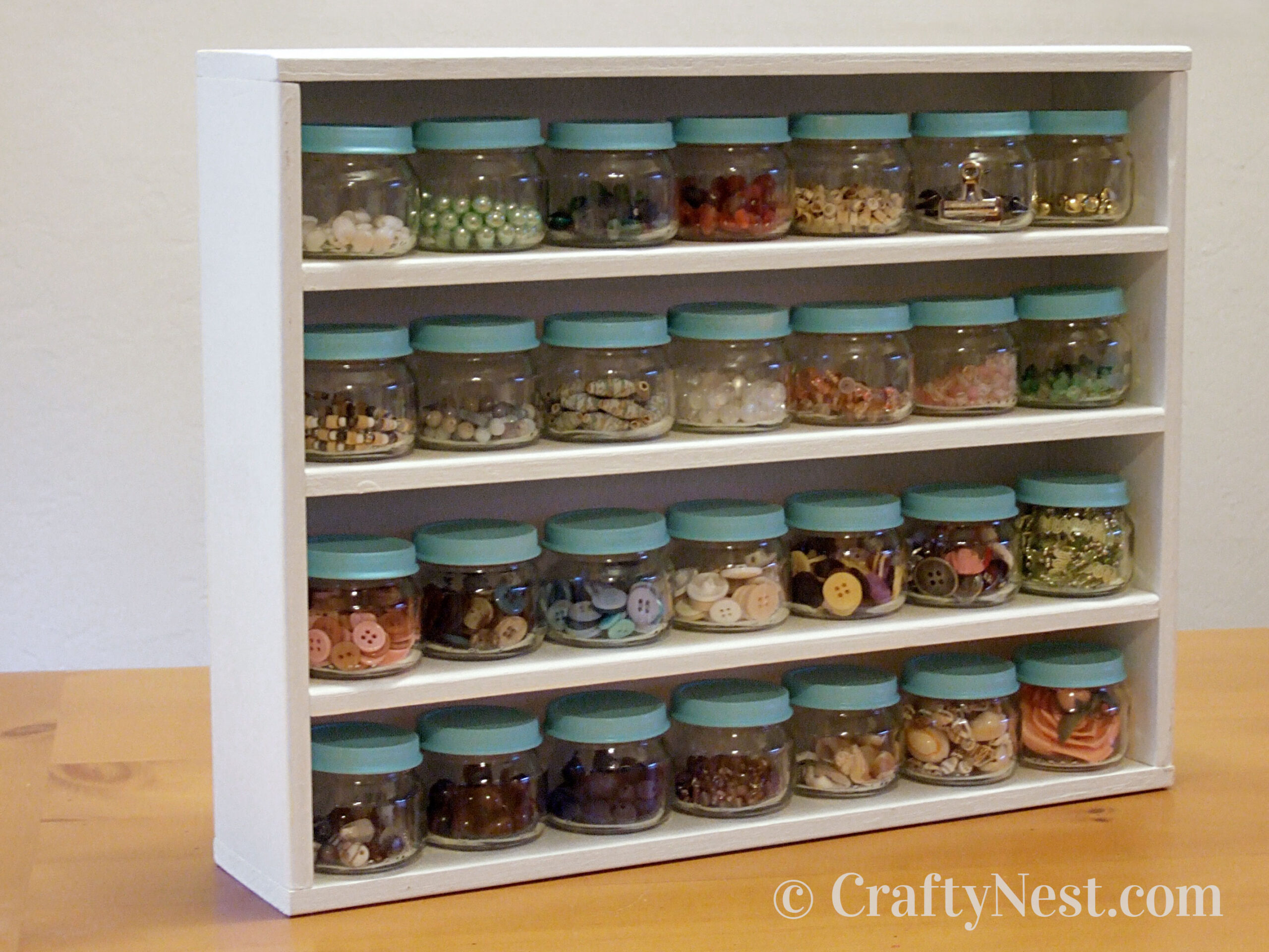 hero-diy-baby-food-jar-craft-rack-crafty-nest Wooden rack with baby-food jars filled with odds and ends, photo