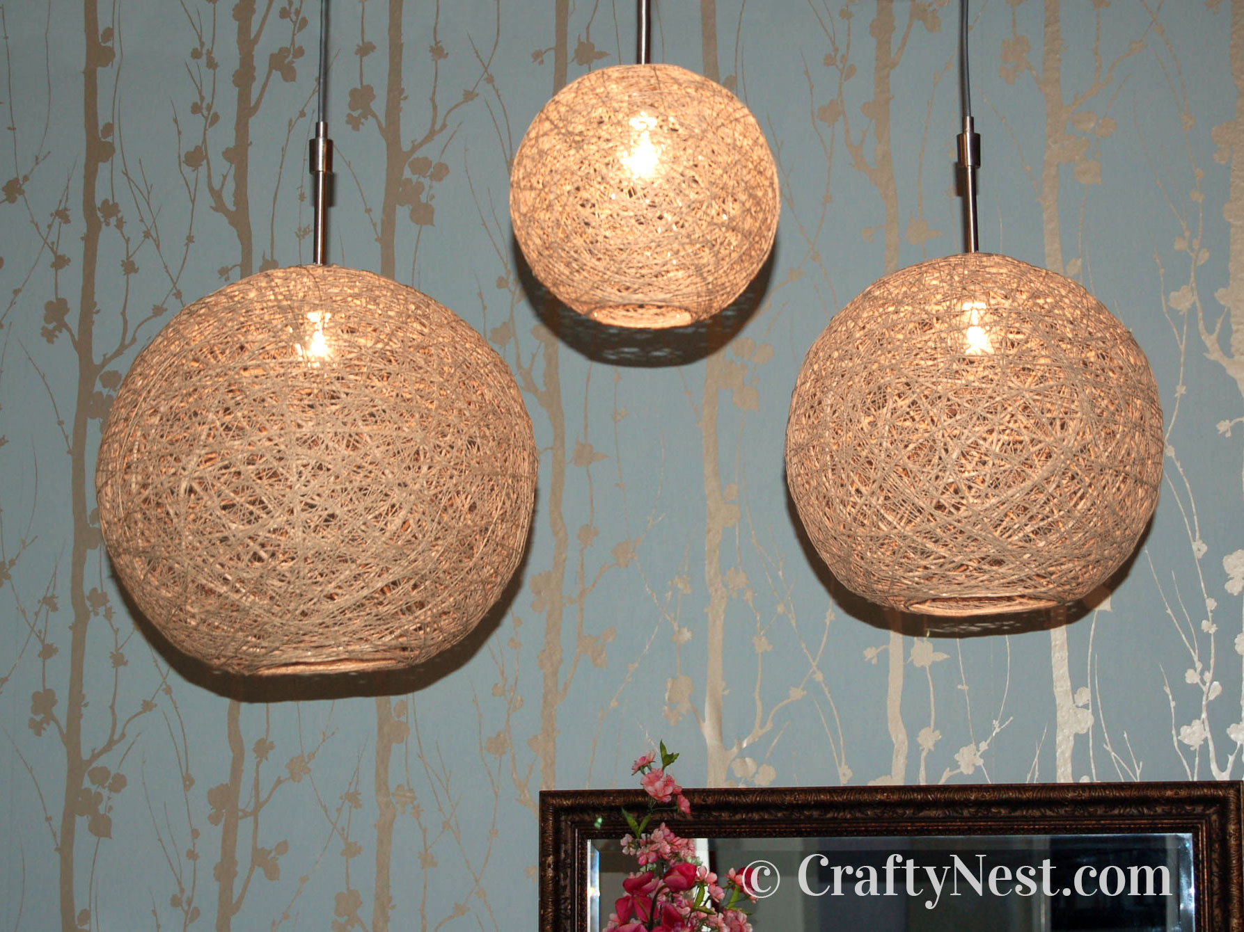 hero-on-hemp-pendant-lamps-crafty-nest Three handmade hemp string pendant lamps with lights on, photo