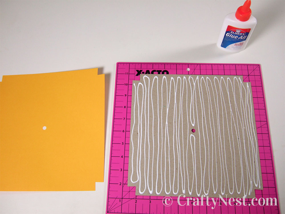 howto3-embossed-numbers-clock-crafty-nest Gluing the clock face to the cardboard, photo