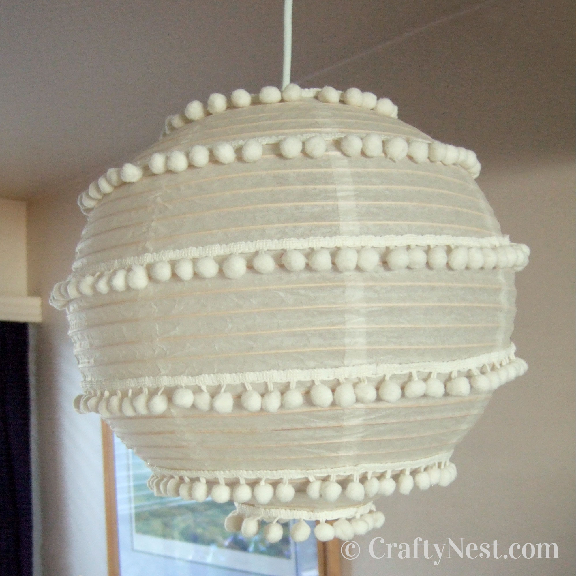 pom-poms-two-paper-lanterns-flowers-pom-poms-crafty-nest Hang the pom-pom lantern, photo