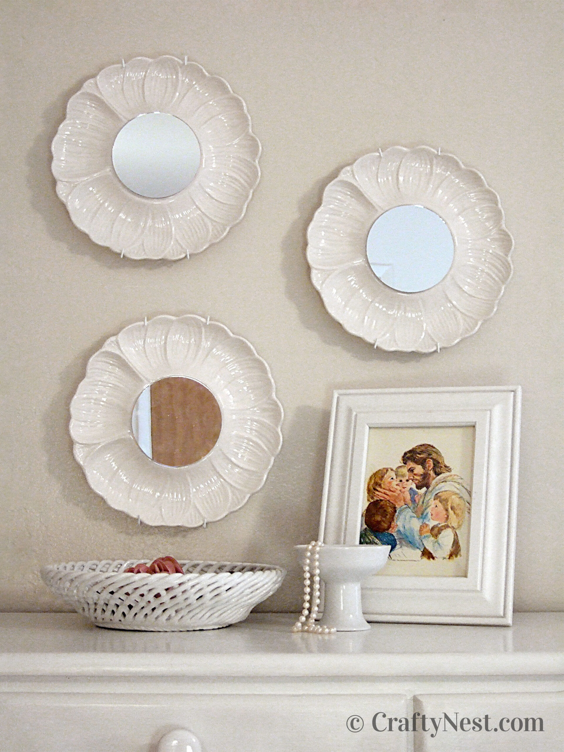 hero-thrift-store-plate-mirrors-crafty-nest Three artichoke plates with mirrors hanging above a dresser, photo