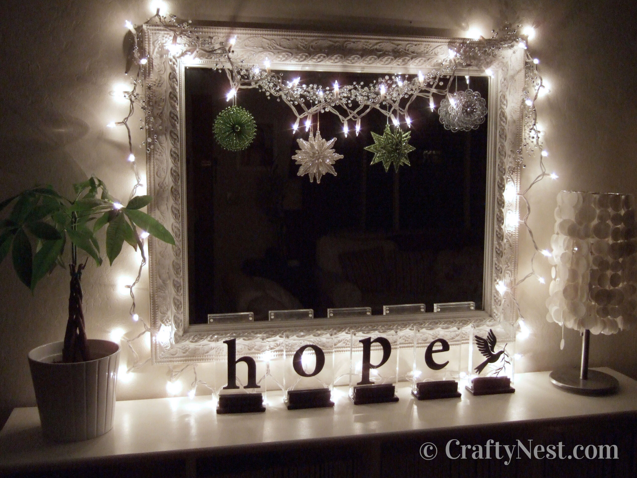 mirror-christmas-lights-angel-with-pants-crafty-nest Lights, ornaments, and garland hanging on mirror, photo