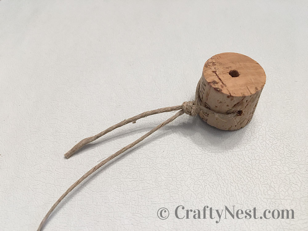 step5-woven-wine-cork-trivet-crafty-nest Tie a knot around the first cork, photo